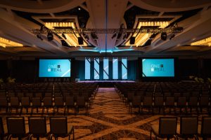 The stage setup at the Real Brokerage conference, 5 LED panels with 2 screens on the sides