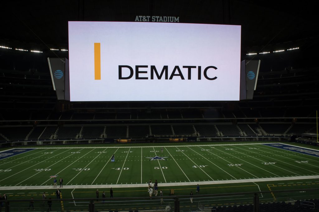 A view of the jumbotron at AT&T stadium where the Dematic logo is displayed. An example of digital signage used for branding for Dematic.