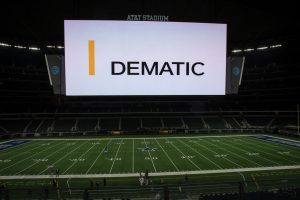 A view of the jumbotron at AT&T stadium where the Dematic logo is displayed. An example of digital signage used for branding for Dematic.