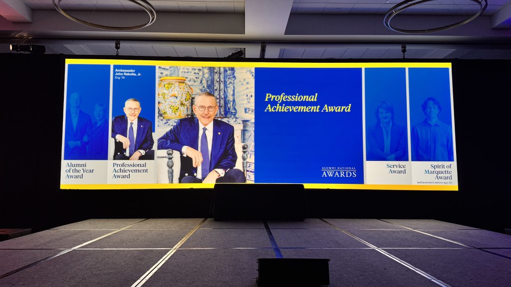 For gallery page: A photo from the Marquette University Alumni National Awards. Features the onstage projector screen and stage setup. 