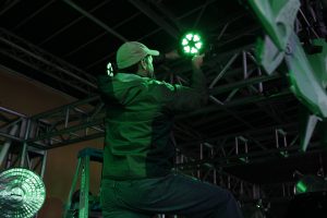 Event Crew Shot. A Technical Director positioning a light during event setup.