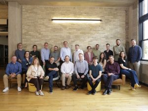 The entire Tri-Marq team posting for a photo in the Eagleknit office building where their headquarters is located.