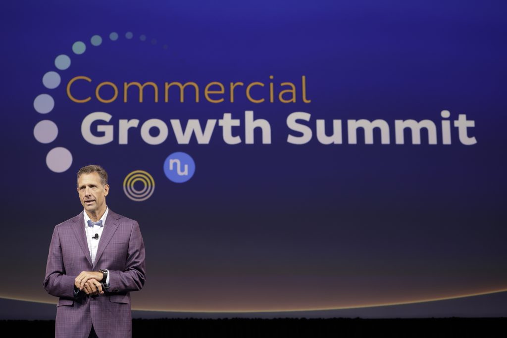 A closeup of a speaker on stage at the Numotion Commercial Growth Summit.
